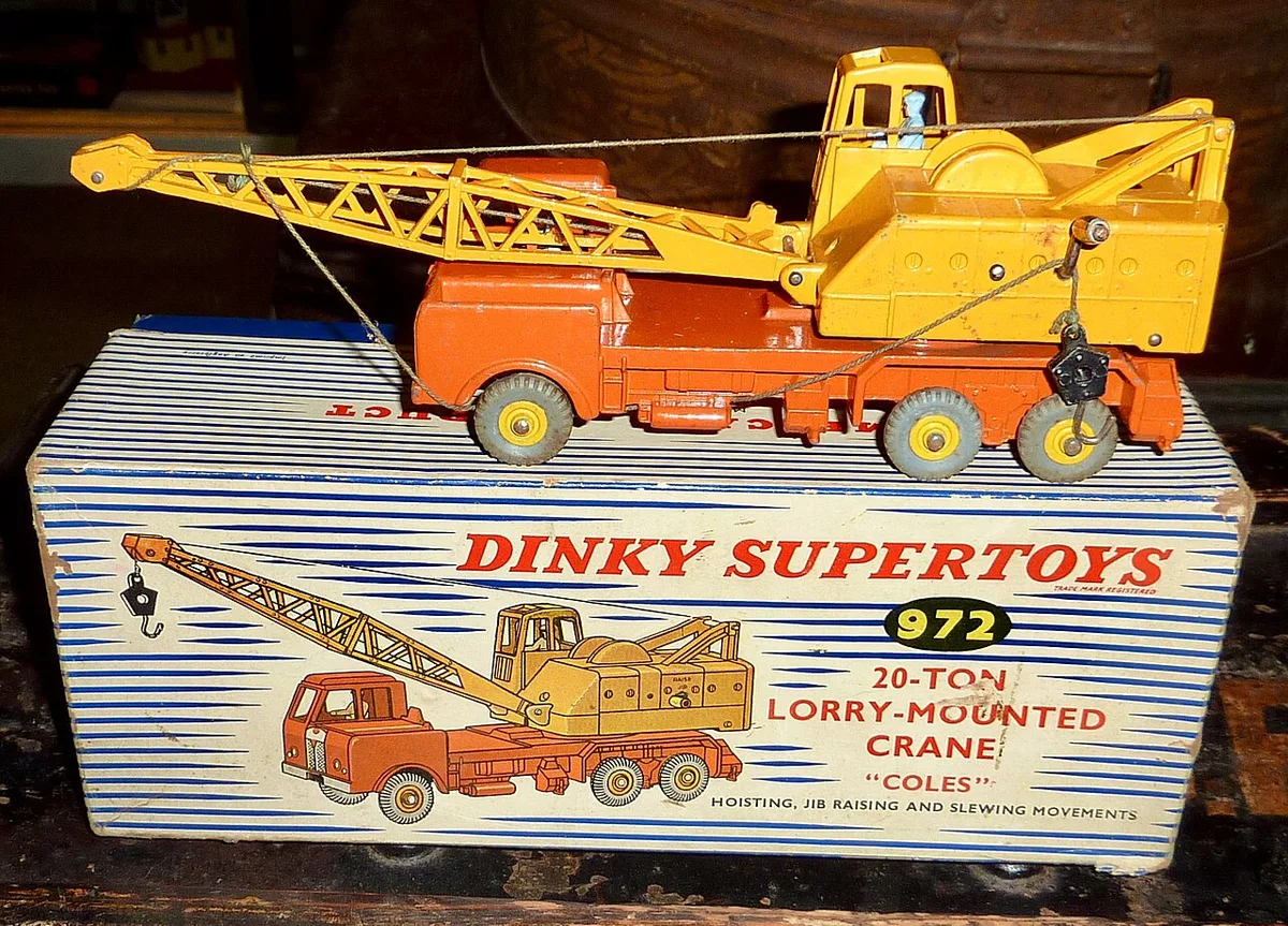 Een oranje-gele Dinky Supertoys hijskraan op vrachtwagenchassis staat op de bijbehorende doos met een gekleurde afbeelding van hetzelfde model.